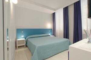 sypialnia z niebieskim łóżkiem w pokoju w obiekcie Hotel Agrigento Home w mieście Agrigento