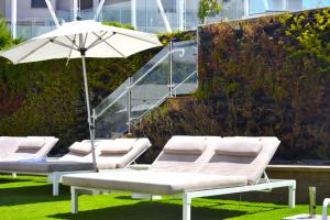 a row of lounge chairs with an umbrella at סי סייד אילת סוויטה מפנקת 3 חדרים מרחק הליכה מהים in Eilat