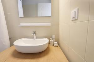 uma casa de banho com um lavatório branco e um espelho. em Thea Studios em Kassiopi mais 37 fotografias