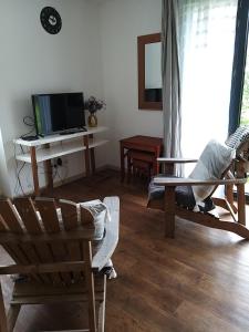 a living room with two chairs and a tv at Sucré salé in Le Port-des-Barques