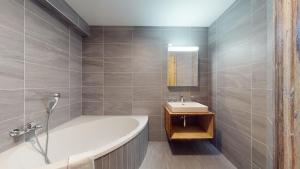 a bathroom with a bath tub and a sink at Les Mayens MA 021 - LUXURY apartment 18 pers in Veysonnaz +23 photos