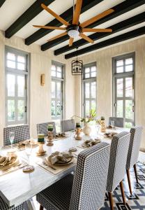 a dining room with a table with chairs and a ceiling fan at LohonoStays Estate de Carmo in Camorlim