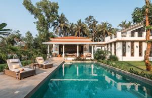 an exterior view of a house with a swimming pool at LohonoStays Estate de Carmo in Camorlim
