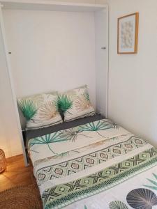 un dormitorio pequeño con una cama con plantas. en Escapade Côtière au Grau du Roi, en Le Grau-du-Roi