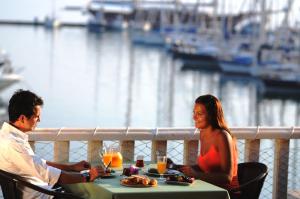 
a man and woman sitting at a table with food at Ece Saray Marina Resort in Fethiye
