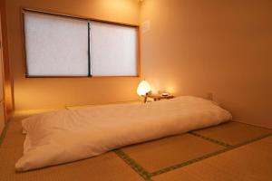 a bedroom with a large white bed with a window at Kiraku Wheat Kiyomizu Temple Absolute Garden and Terrace Designer Studio in Kyoto