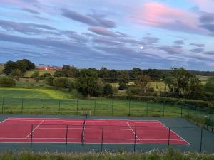 a tennis court with a tennis court at Garden Bank Cottage in Kelso