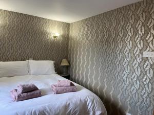 a bedroom with a bed with two towels on it at Garden Bank Cottage in Kelso