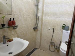 Un baño con ducha, lavabo e inodoro. en Cozy Corner, en Ouakam
