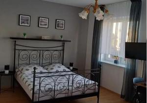 a bedroom with a bed with a wrought iron headboard at AZALIA 30 POKOJE GOŚCINNE , Mielno AZALIOWA 30 in Mielno