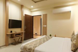 una camera da letto con un letto e una TV a schermo piatto di Hotel Mahadev Villa Elite a Jaipur