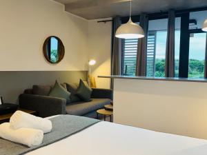 德班Sibaya Coral Point Studio Apartment的一间酒店房间，里面有一张床和一张沙发 更多35张照片