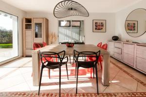 ein Esszimmer mit einem Holztisch und roten Stühlen in der Unterkunft Villa on the Makila golf course near Biarritz in Bassussarry