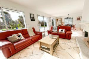 ein Wohnzimmer mit 2 Ledersofas und einem Tisch in der Unterkunft Villa on the Makila golf course near Biarritz in Bassussarry + 23 Fotos