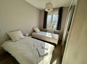 a small room with two beds and a window at Maison Face à Palestra avec Jardin & Confort in Chaumont