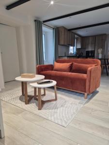 a living room with a couch and two tables at Campagne - appartement rénové avec 2 chambres in Estavayer-le-Lac +4 photos