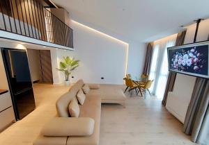a living room with a couch and a flat screen tv at Tirana Sunset Retreat Stylish Loft by the Lake Park in Sauk