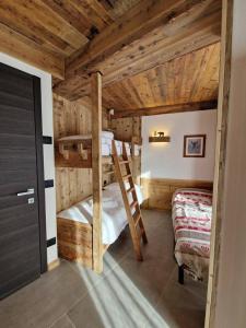 2 letti a castello in una camera con soffitti in legno di Dolom Love Larice PadolaDolomiti a Padola 1 altra foto