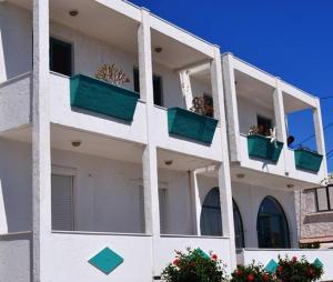 a white apartment building with green balconies on it at Arant in Mastihari