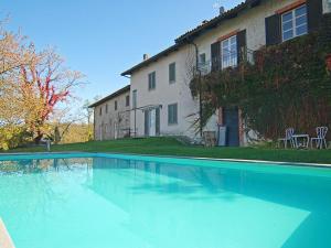 a large swimming pool in front of a house at Agriturismo Minaldo in Dogliani
