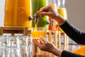 eine Frau füllt ein Glas mit Orangensaft in der Unterkunft Hotel Euroski Mountain Resort & Spa in Soldeu + 54 Fotos