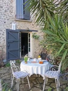 a table with two chairs and a table with food on it at Appartement 3 pièces, jardin, garage in Laroque-des-Albères
