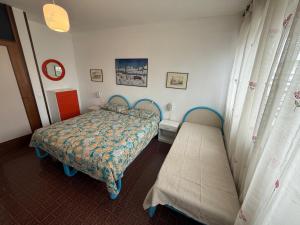 a bedroom with a bed and a bench in it at RESIDENCE MARINA MARCONI - Solo per famiglie in Lido di Jesolo