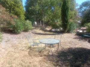 a table and two chairs sitting in a yard at T3 Baziege in Baziège