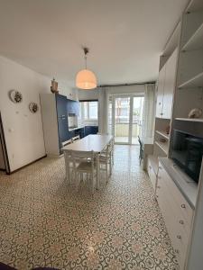 a kitchen and dining room with a table and chairs at RESIDENCE MARINA MARCONI - Solo per famiglie in Lido di Jesolo