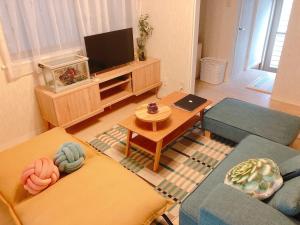 a living room with two couches and a tv at RInnオリジナル天下茶屋 松 in Osaka