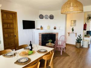 une salle à manger avec une table et une cheminée dans l'établissement Cortijo Montesuenos con vistas by At Home, à Torrox