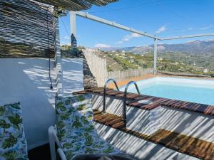 - un balcon avec une table et une piscine dans l'établissement Cortijo Montesuenos con vistas by At Home, à Torrox