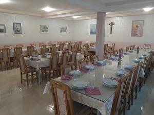 a long table in a room with chairs and tables sidx sidx at Pansion San Pietro in Međugorje