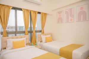 two beds in a room with a window at Z Bliss Suites, BKC in Mumbai +56 photos