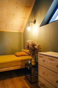 a room with two beds and a table with a lamp at Domek SzumiSosna1 in Raków