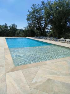 a swimming pool with blue water and some chairs at Recientemente restaurada, ideal para grupos! in Cabanellas