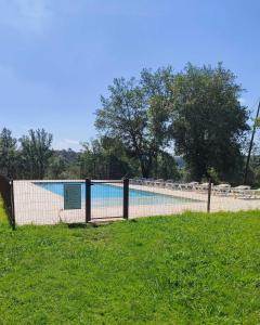 a tennis court in a field next to a pool at Recientemente restaurada, ideal para grupos! in Cabanellas