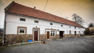 a dog laying in front of a white building at Ranczo u Jana in Stronie Śląskie