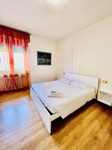 a bedroom with a large white bed in a room at Residenza Bouganville in Torri del Benaco