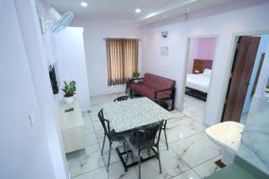 a living room with a table and a couch at Madayi Residency in Pālayangadi