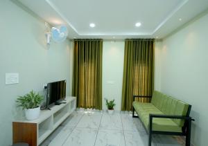 a living room with a couch and a tv at Madayi Residency in Pālayangadi