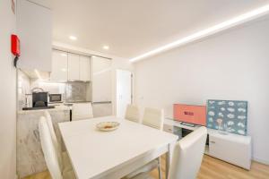a kitchen and dining room with a white table and chairs at GuestReady - Sunny Sesimbra Escape in Sesimbra