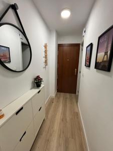 a hallway with a mirror and a dresser and a door at Pamplona Home in Pamplona