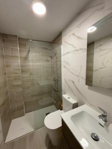 a bathroom with a toilet and a shower and a sink at Pamplona Home in Pamplona