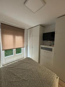 a bedroom with a bed and a television and a window at Pamplona Home in Pamplona
