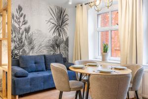 a living room with a blue couch and a table at Apartamenty Belona Puck in Puck
