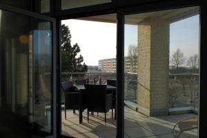 a patio with a table and chairs on a balcony at Inselblume 55 - Ferienwohnung in der Strandburg mit Hund in Burgtiefe auf Fehmarn 