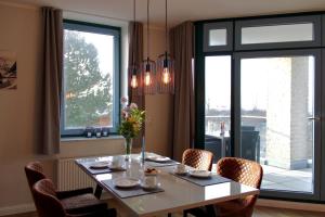 a dining room with a table and chairs and a window at Inselblume 55 - Ferienwohnung in der Strandburg mit Hund in Burgtiefe auf Fehmarn 