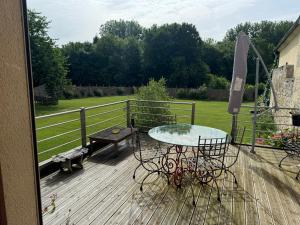 a wooden deck with a table and chairs on it at Gîte du fief in Cires-lès-Mello