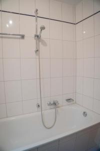 a shower in a bathroom with a tub at Inselblume 78 - Ferienwohnung mit Strandkorb in Burgtiefe in Burgtiefe auf Fehmarn  +16 photos